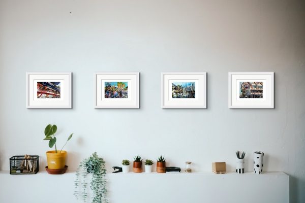 Room setting featuring A4 prints of paintings Flaming Piper, Sketching London, Sketchiing London and Victorian Destinations created by contemporary artist Cathy Read