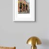 Room setting with and A3 print of Passing the Portico Library, an original painting by Contemporary artist Cathy Read. Featuring the Portico Library in Manchester.