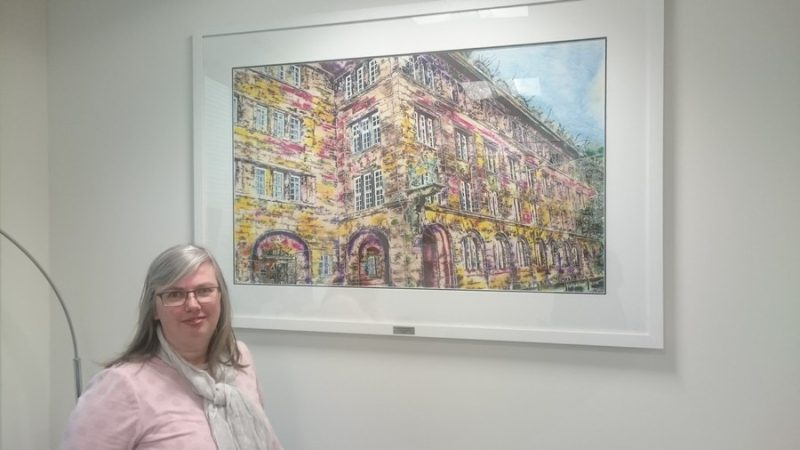 Cathy Read with her painting of Bahlsen's Hanover Headquarters in Germany. Taken in the reception area of Bahlsen's offices in Chalfont St Peter, UK