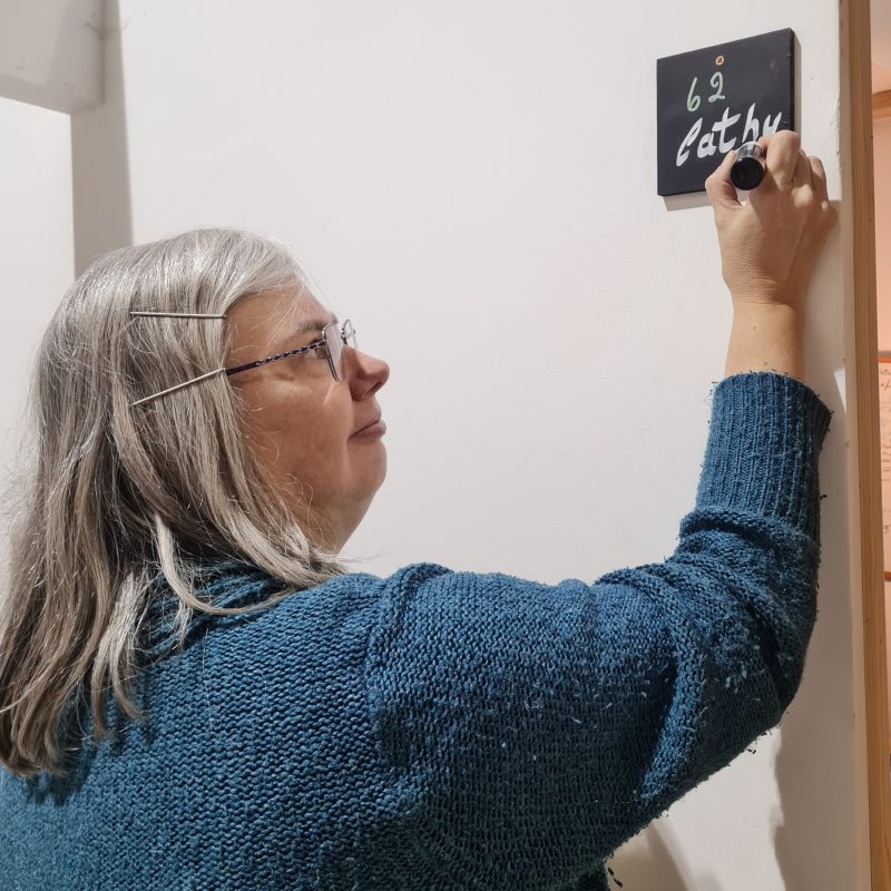 Cathy writing her name on the side outside her new studio
